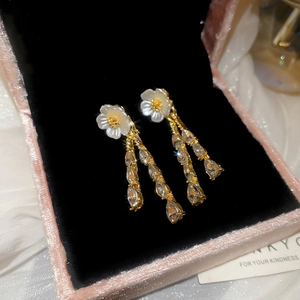 Macro detail of silver needle flower earrings with zircon water drop tassel pendants