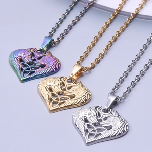 Detailed macro view of heart-shaped wolf head pendants in iridescent gold and silver finish