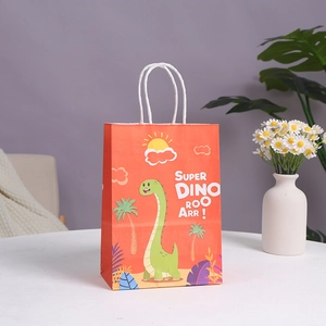 Orange dinosaur theme paper gift bag with white rope handles on a clean white tabletop