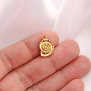Macro shot of 18K gold plated conch shell pendant accessory held by hand for detail