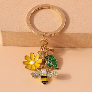 Detail of bee keychain with rhinestones, pearl accents, flower and leaf charms