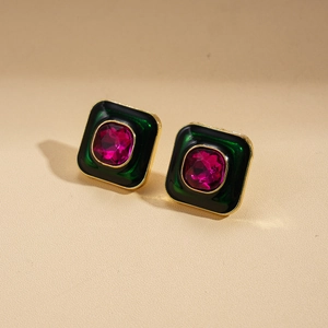Gros plan de boucles d'oreilles carrées vintage avec pierre rose et émail vert doré