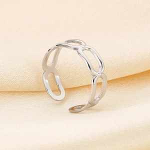 Detailed view of silver chain-link stainless steel ring on soft beige silk background