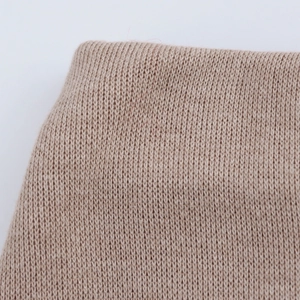 Close-up of light brown knit fabric detail with soft wool blend weaving texture