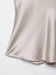 Close-up of champagne satin fabric showing fine rolled hem and silky texture detail