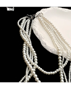 Elegant multi-layer white faux pearl necklace with metallic clasp on a display tray