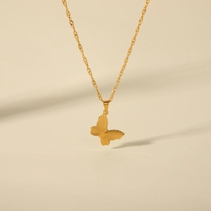 Close-up of a detailed golden butterfly pendant on a delicate chain necklace