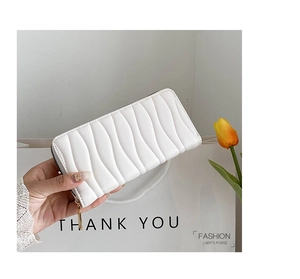 Detail of white wave-quilted PU leather long wallet with gold zipper and Tulip decoration