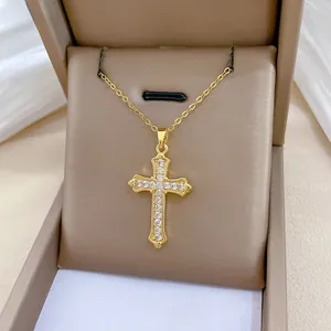 Close-up of golden titanium steel cross pendant with sparkling cubic zirconia inlay