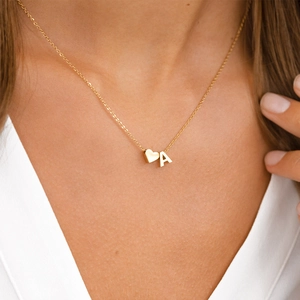 Detailed view of a personalized gold necklace featuring a 3D heart and initial 'A' charm