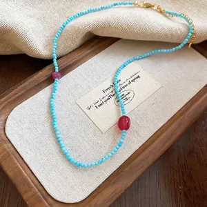 Ethnic stainless steel necklace with blue beads and star pendant on a burlap background