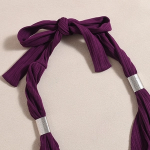 Detailed view of dark purple ribbed knit fabric with silver metal ring and halter neck tie