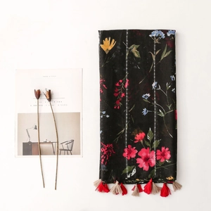 Vintage floral scarf with sequins and red tassels on black linen texture background