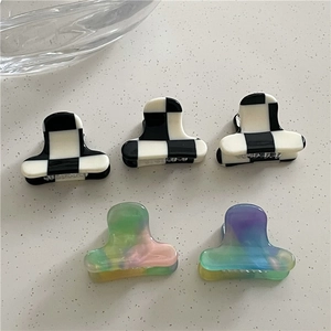 Close-up of acetate mini hair claws in checkerboard and macaron gradient patterns