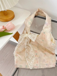 Floral bow handbag with large lace detail hanging on a chair in a cozy room