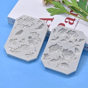Grey silicone molds with floral and bird relief patterns for DIY cake baking and crafts