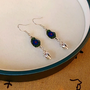 Detailed silver earrings with colorful enamel lotus bud pendant in a ceramic tray
