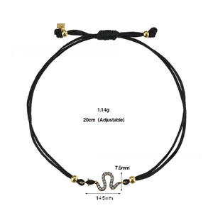 Detail of adjustable black cord bracelet featuring a zircon snake pendant and gold beads