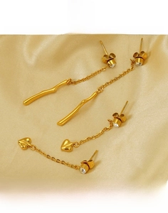 Detail of gold titanium steel earrings with tassel chains and crystal pendants