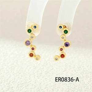 Detail of gold earrings with a cascade of colorful round-cut zircon stones and high shine
