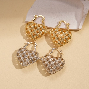 Minimalist gold and silver hollow heart earrings with woven texture on stone surface
