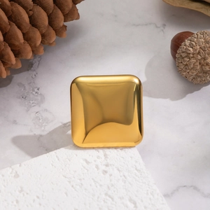 Polished 18K gold-plated square earring accessory on white textured marble surface