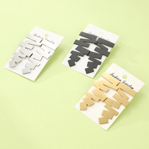 Detailed view of geometric jagged earrings in gold, silver, and black finish on cards