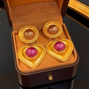 Vintage gold earrings with brown and burgundy pearls inside a brown jewelry box