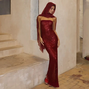 Dettaglio dell'abito da sera rosso con paillettes, scollo a cuore e spacco laterale