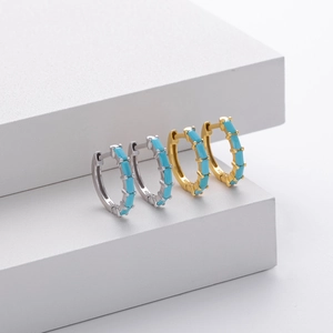 Detail of square turquoise stone inlay on gold and silver 925 sterling silver earrings