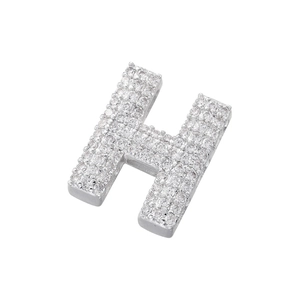 Macro detail of silver H-letter pendant with micro-paved cubic zirconia stones