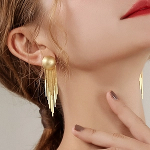Elegant gold long tassel drop earrings worn by model featuring metal dangling chains