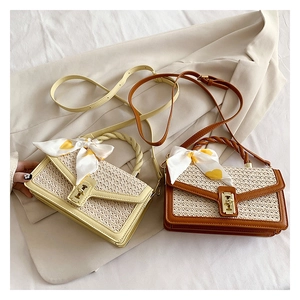 Detail of straw crossbody bags with silk scarf and leather trim in beige and brown