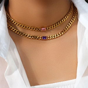 Close-up of double layered gold Cuban chain necklace with pink and purple square zircons
