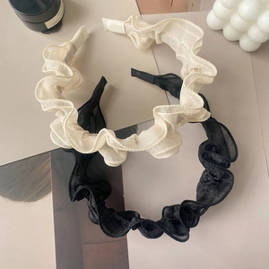 Elegant ruffled mesh headbands in beige and black displayed on aesthetic background