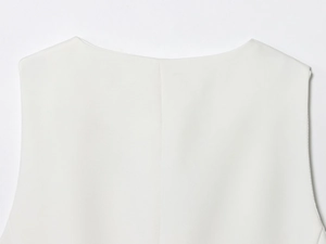 Détail du haut blanc sans manches montrant le col rond et la texture du tissu