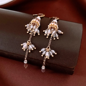 Close-up of handmade ethnic beaded tassel earrings with crystal glass on leather