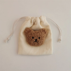 Detail of corduroy drawstring bag with a cute 3D plush bear head in a minimalist style