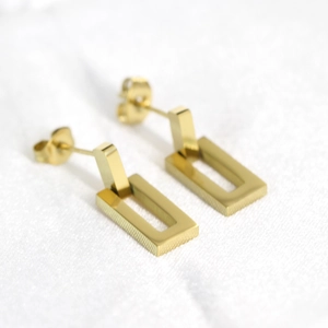 Macro shot of 18K gold plated stainless steel hollow rectangle earrings on fabric