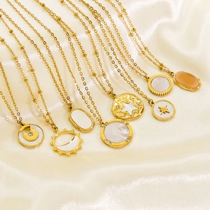 Luxe stainless steel necklaces with celestial sun and moon pendants on silk