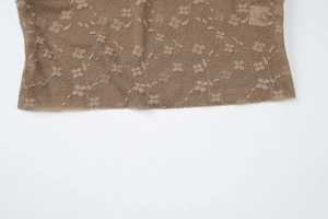 Détail du tissu en dentelle florale marron sur l'ensemble robe midi bustier sexy