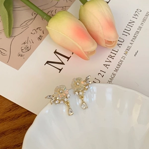 Detailed shot of frosted flower clip-on earrings with pearls on shell tray