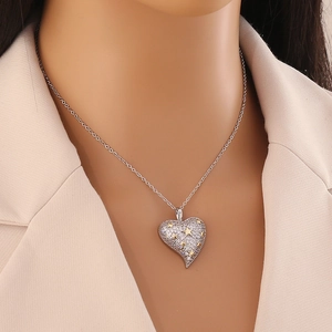 Collier avec pendentif cœur bicolore or et argent porté par un mannequin avec motifs étoiles
