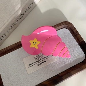 Pince à cheveux coquillage rose avec étoile jaune et détails dorés élégants