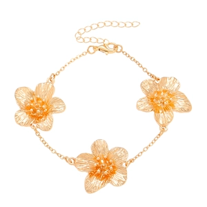 Golden flower bracelet with textured petals and lobster clasp on white background