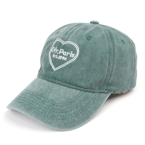 Macro detail of teal green washed cotton cap with heart and Ofr. Paris embroidery
