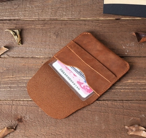 Macro shot of brown Crazy Horse leather wallet showing card slots and transparent window