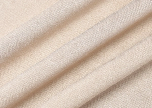 Détail du tissu soyeux avec des plis diagonaux élégants et un éclat doré satiné