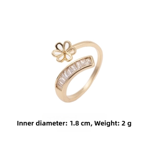 Detail of adjustable gold ring featuring a hollow flower and baguette zircon inlay