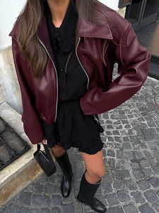 Détail d'une veste en similicuir bordeaux avec revers larges et fermeture éclair en métal